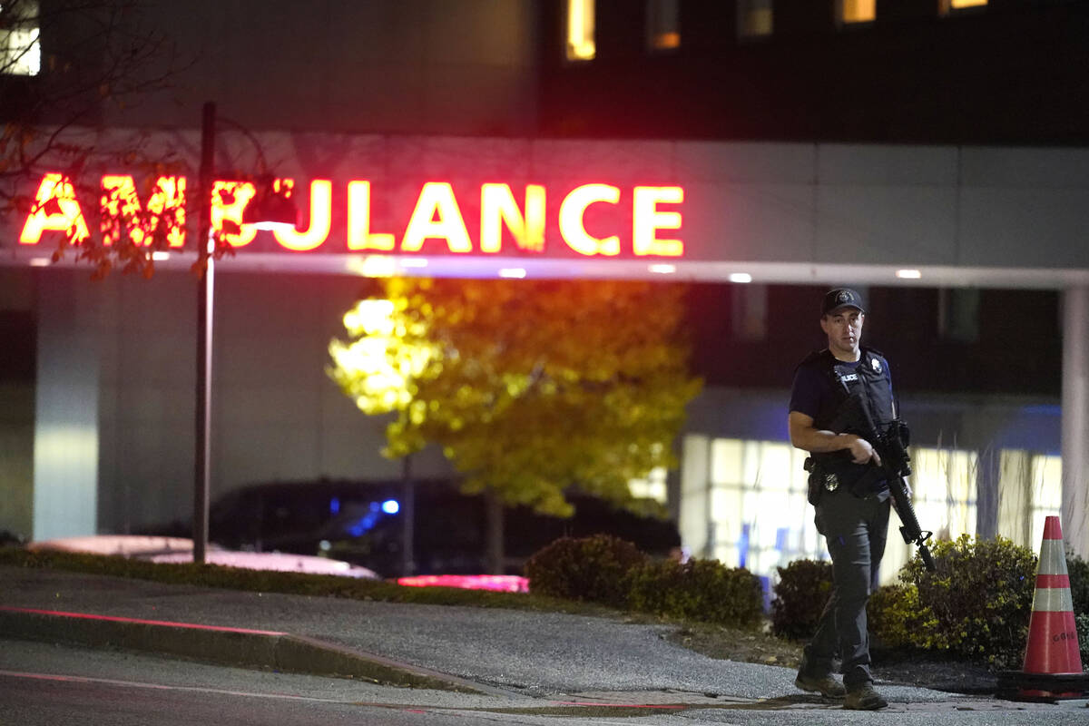 A law enforcement officer carries a rifle outside Central Maine Medical Center during an active ...