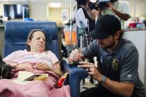 Shea Theodore, defenseman for the Golden Knights, signs a puck for patient Roberta Williams at ...