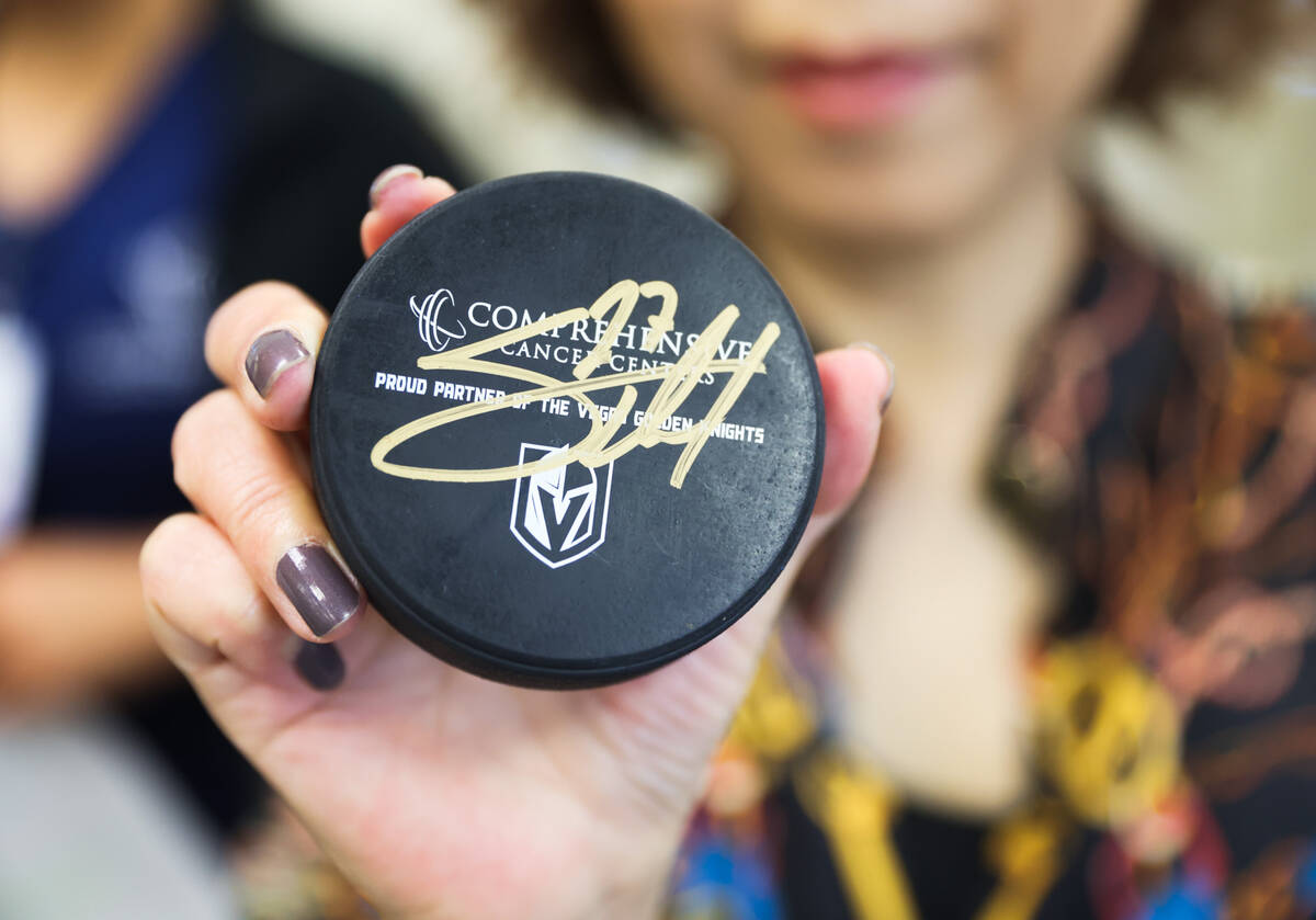 Patient Christine Kochien holds a puck with the signature of Shea Theodore, defenseman for the ...