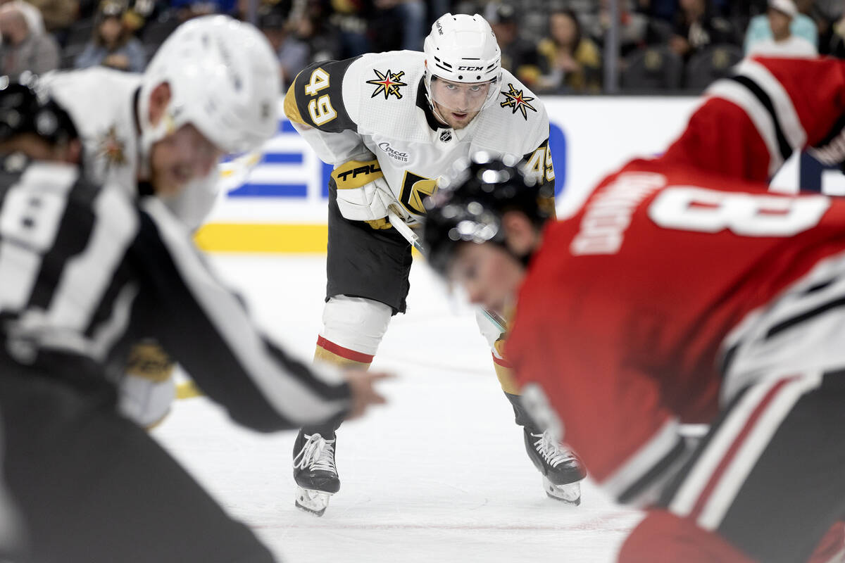 Golden Knights center Ivan Barbashev (49) eyes the puck during a face-off with the Blackhawks d ...