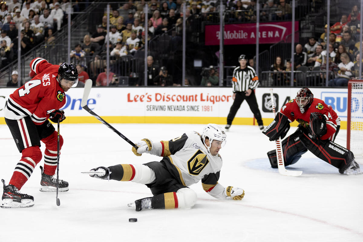 Golden Knights center Chandler Stephenson (20) falls to the ice on his way to the net after Bla ...