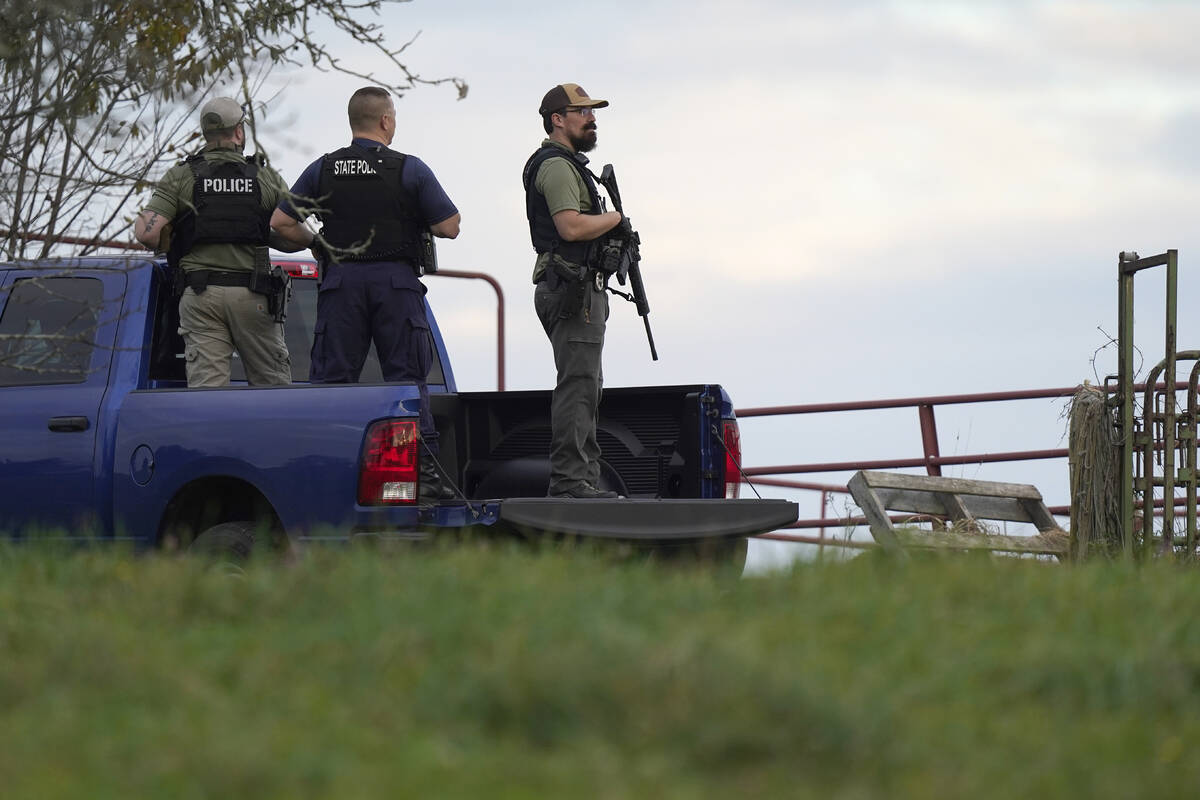 Law enforcement officers hold rifles while investigating a scene, in Bowdoin, Maine, Thursday, ...