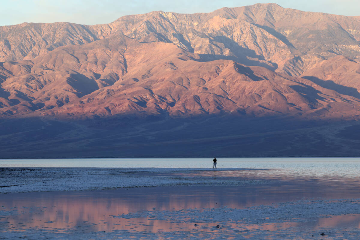 A visitor checks out a rare lake in Badwater Basin in the recently reopened Death Valley Nation ...