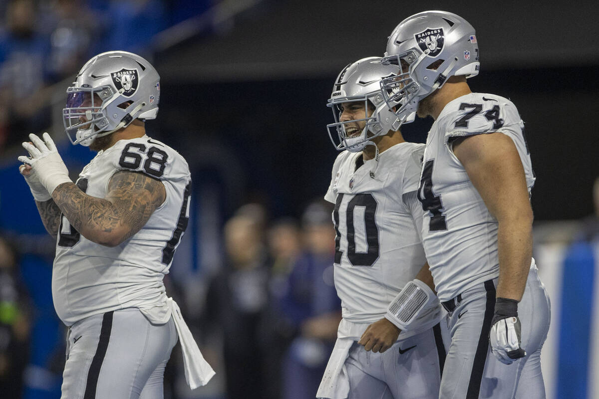 Raiders quarterback Jimmy Garoppolo (10) grimaces after being hit and walks back to the line of ...