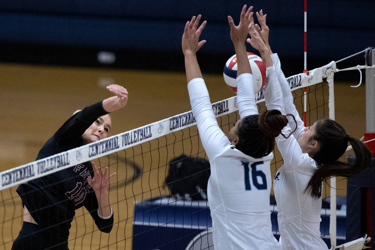 Faith Lutheran's Ella Swinn (10) has a shot killed by Centennial middle blocker Jada Thomas-Swi ...