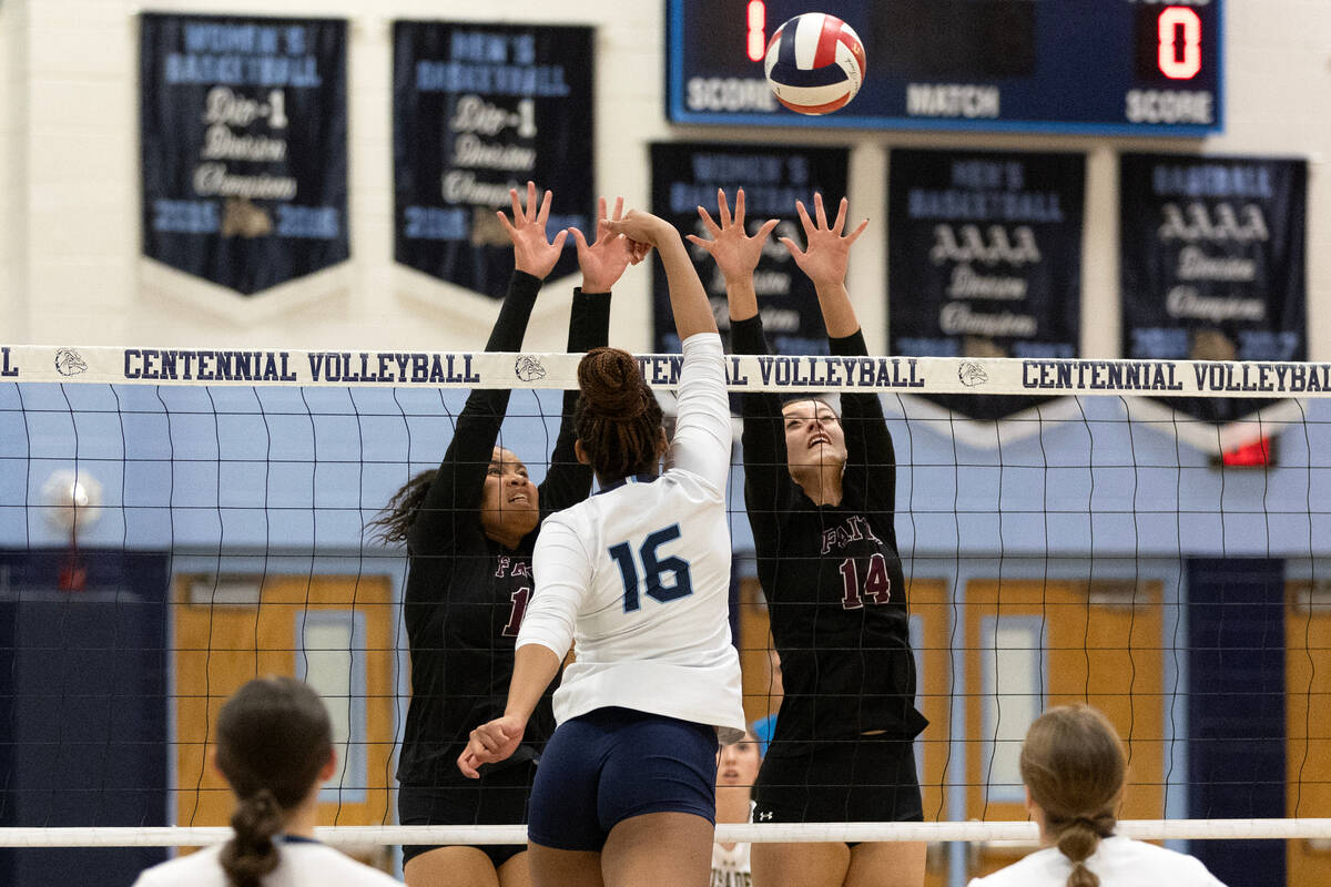 Centennial middle blocker Jada Thomas-Swinson (16) gets a shot over Faith Lutheran middle block ...