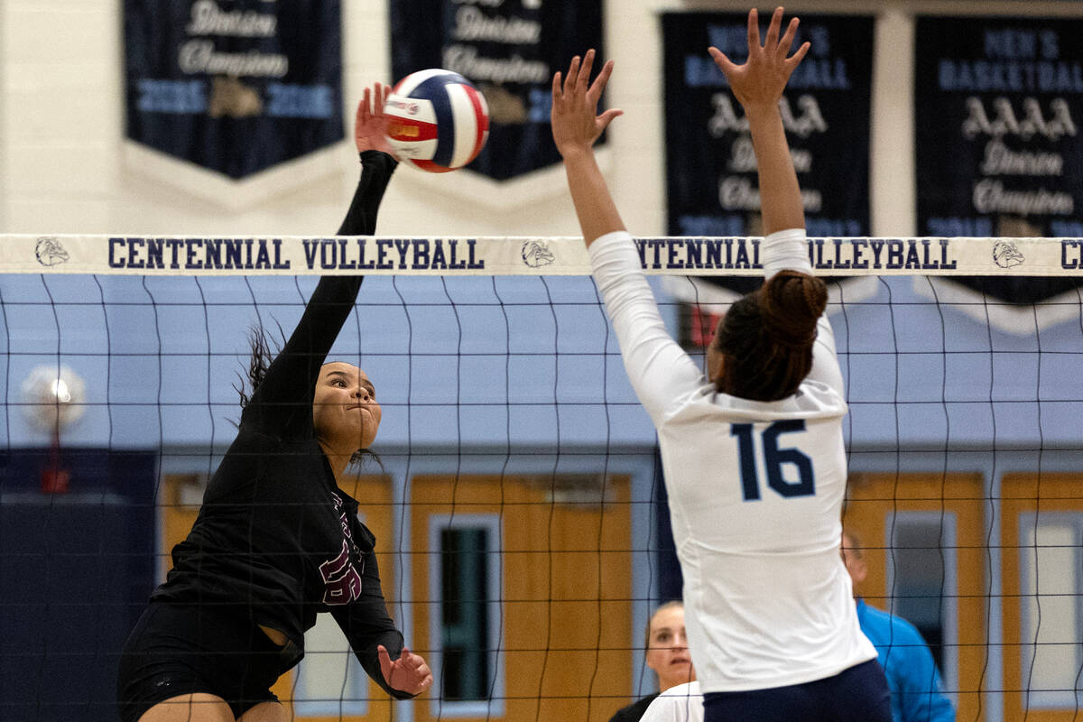 Faith Lutheran middle blocker Andrea Romero-Agosto (16) hits against Centennial middle blocker ...