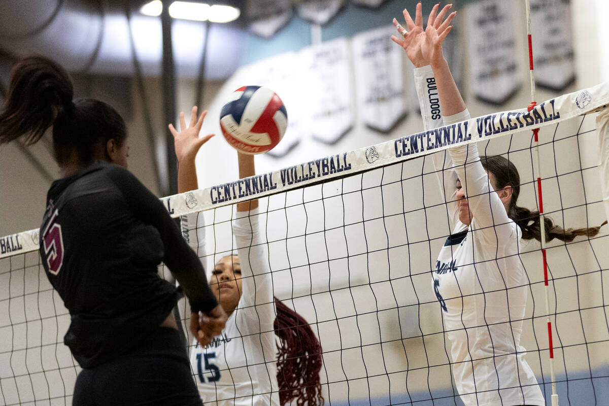 Faith Lutheran's Taly Cloyd (5) hits against Centennial middle blocker Aliah Williams (15) and ...