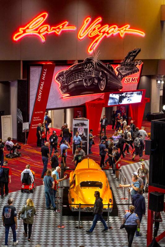 Attendees check out a classic car at the Central Hall entrance during the first day of SEMA at ...