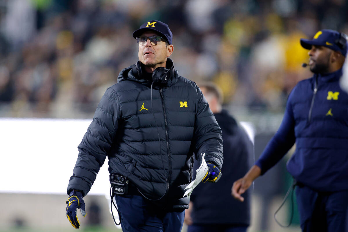 Michigan coach Jim Harbaugh watches during an NCAA college football game against Michigan State ...