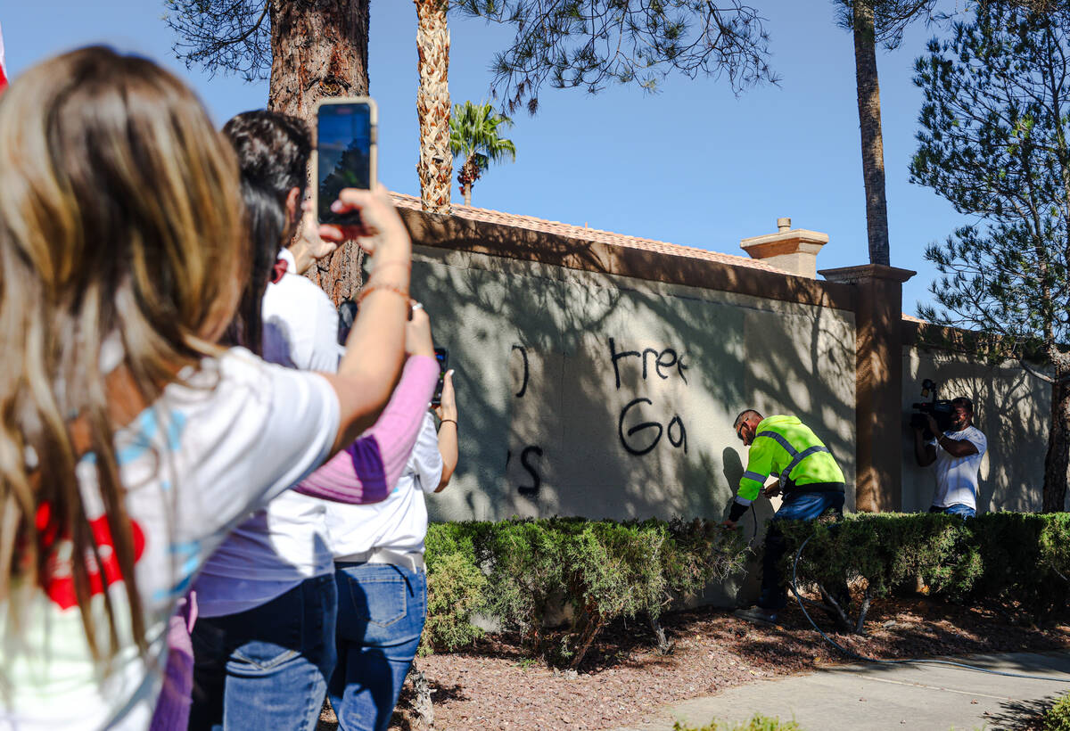 Pro-Israel demonstrators film a city worker spray over graffiti written the night before that s ...