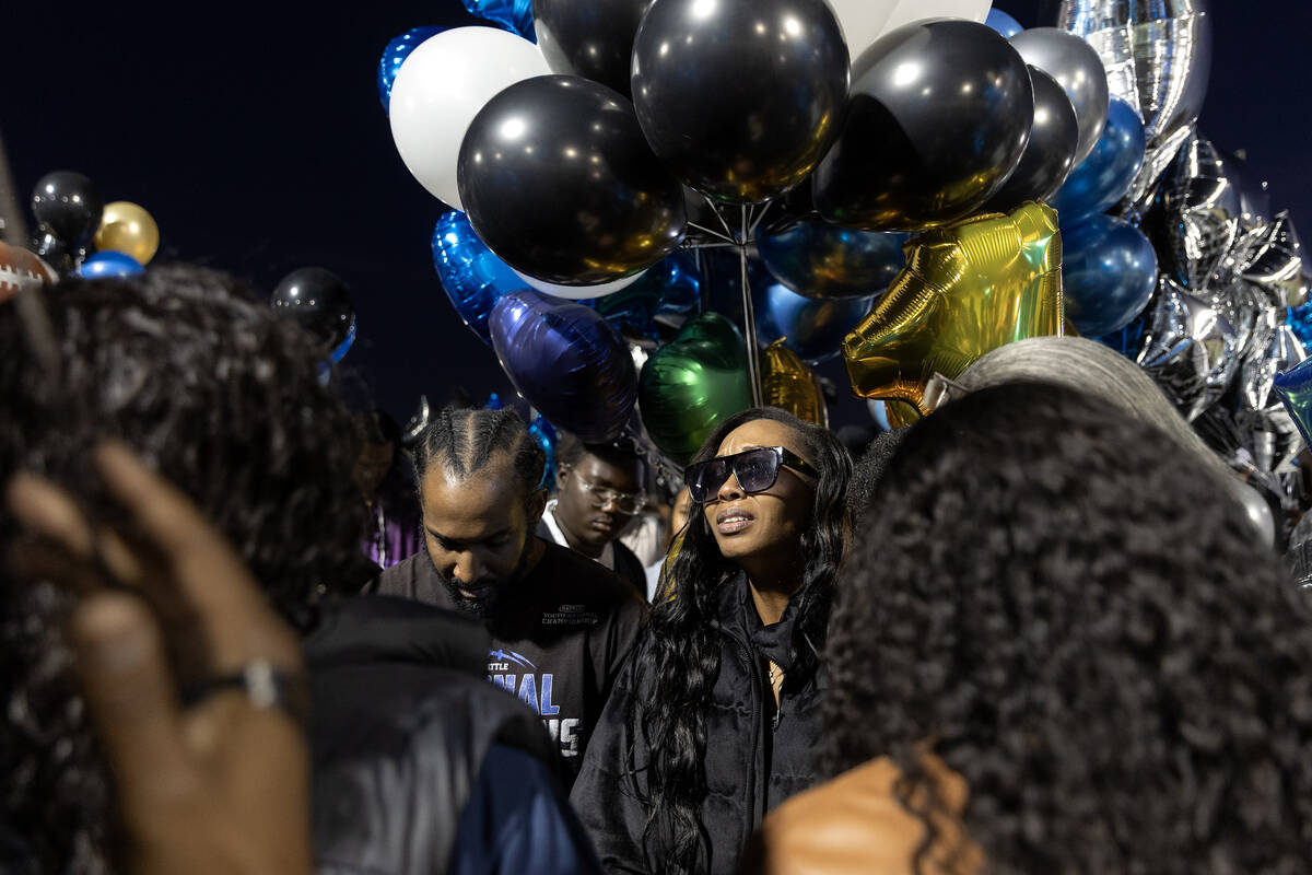 Maureisha Johnson, center right, prays during a vigil for her son, Desert Pines High School foo ...