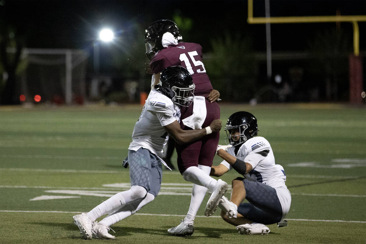 Desert Pines linebacker Semauri Norris-Johnson, left, tackles Faith Lutheran quarterback Alex R ...