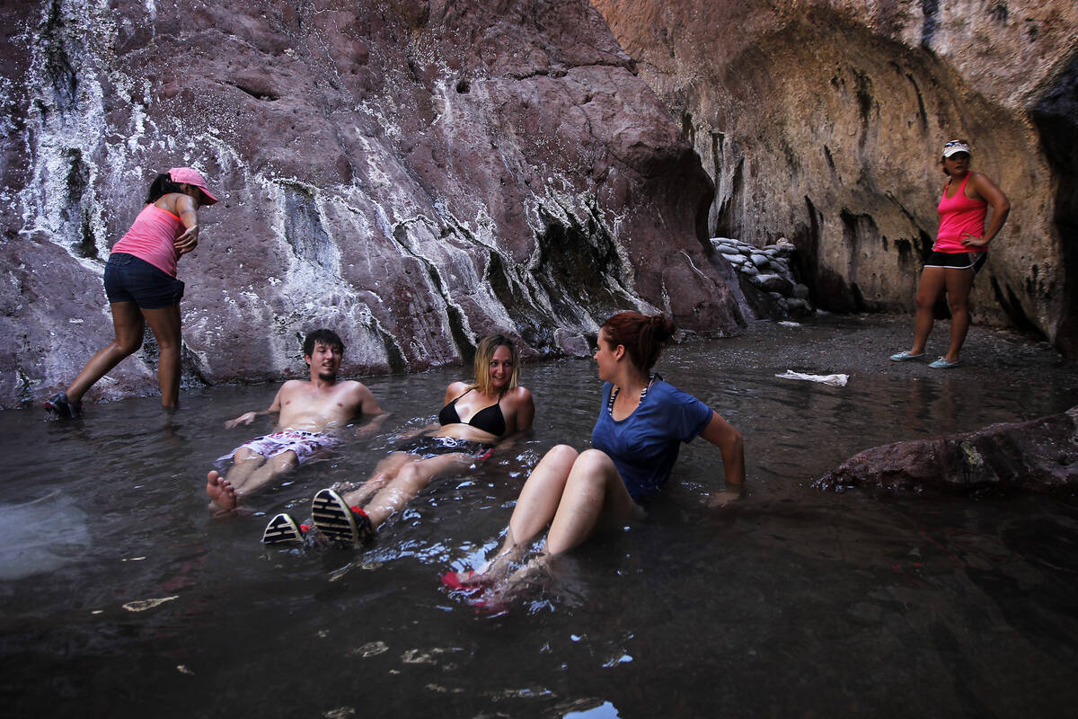 From left, Matt Fields, Gilliane Holt and Brooke Cannon relax in a hot springs pool above Arizo ...