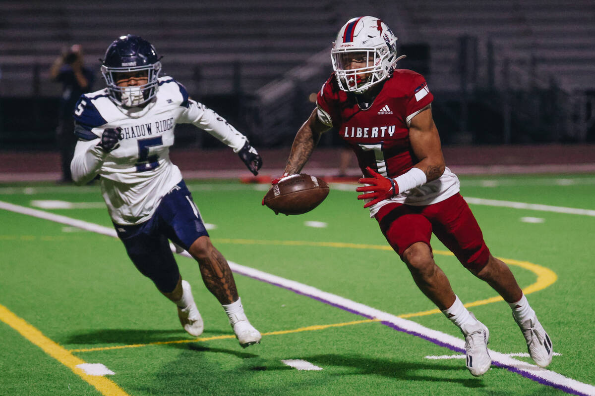 Liberty running back Jayden Robertson runs the ball as Shadow Ridge linebacker Keau Hadley Jr. ...