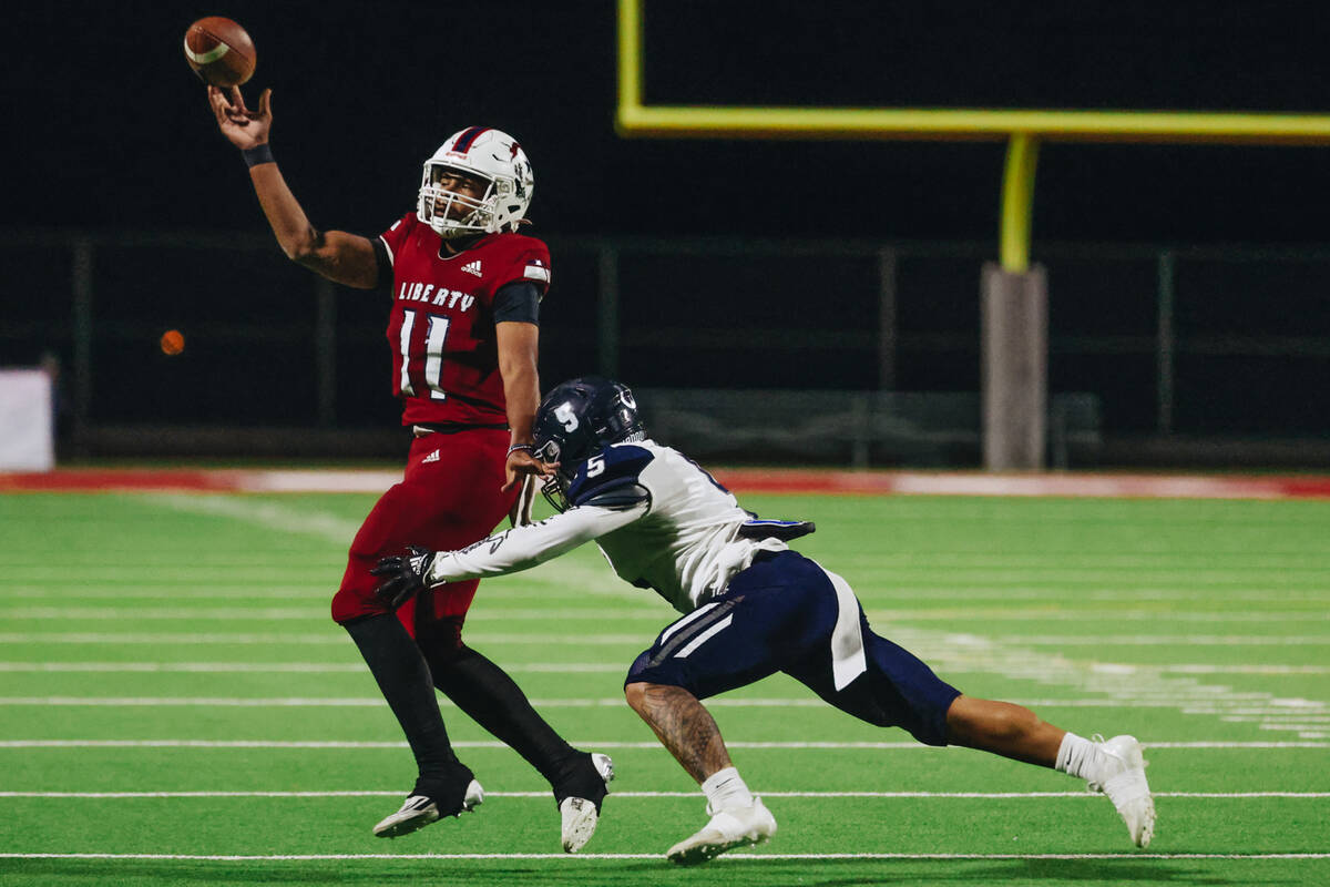 Liberty quarterback Tyrese Smith (11) throws the ball to a teammate as Shadow Ridge linebacker ...