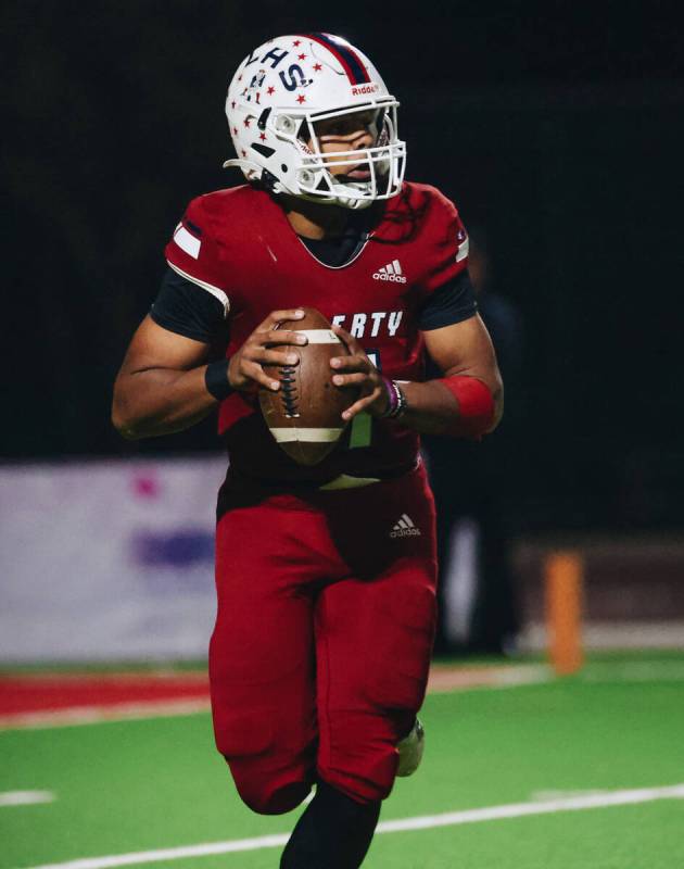 Liberty quarterback Tyrese Smith (11) looks to pass the ball to a teammate during a game agains ...