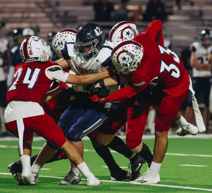 Shadow Ridge running back Evan Cannon gets caught with the ball between Liberty defenders durin ...