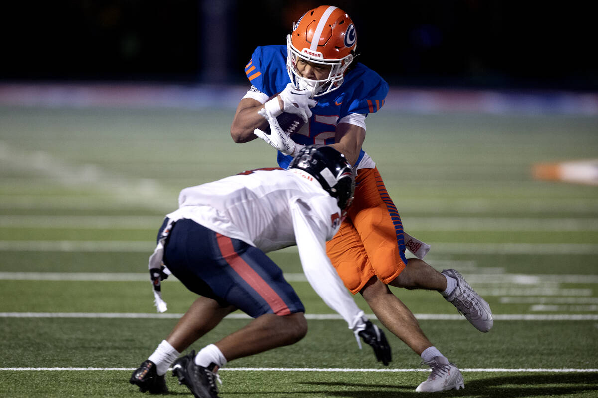 Bishop Gorman running back Micah Kaapana (22) runs the ball while avoiding a tackle by Coronado ...