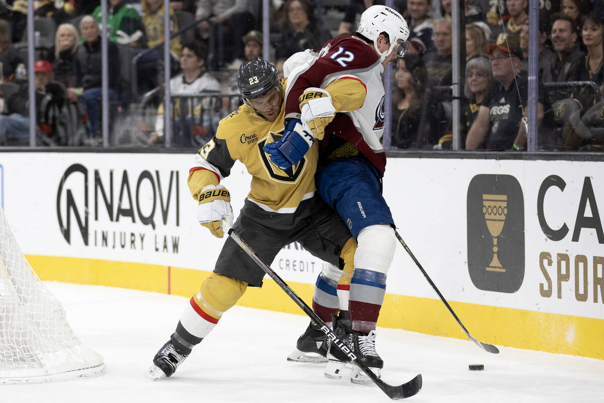 Golden Knights defenseman Alec Martinez (23) works the puck away from Avalanche center Ryan Joh ...