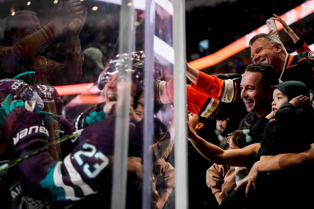 Fans, right, celebrate after a goal by Anaheim Ducks center Mason McTavish (23) during the thir ...