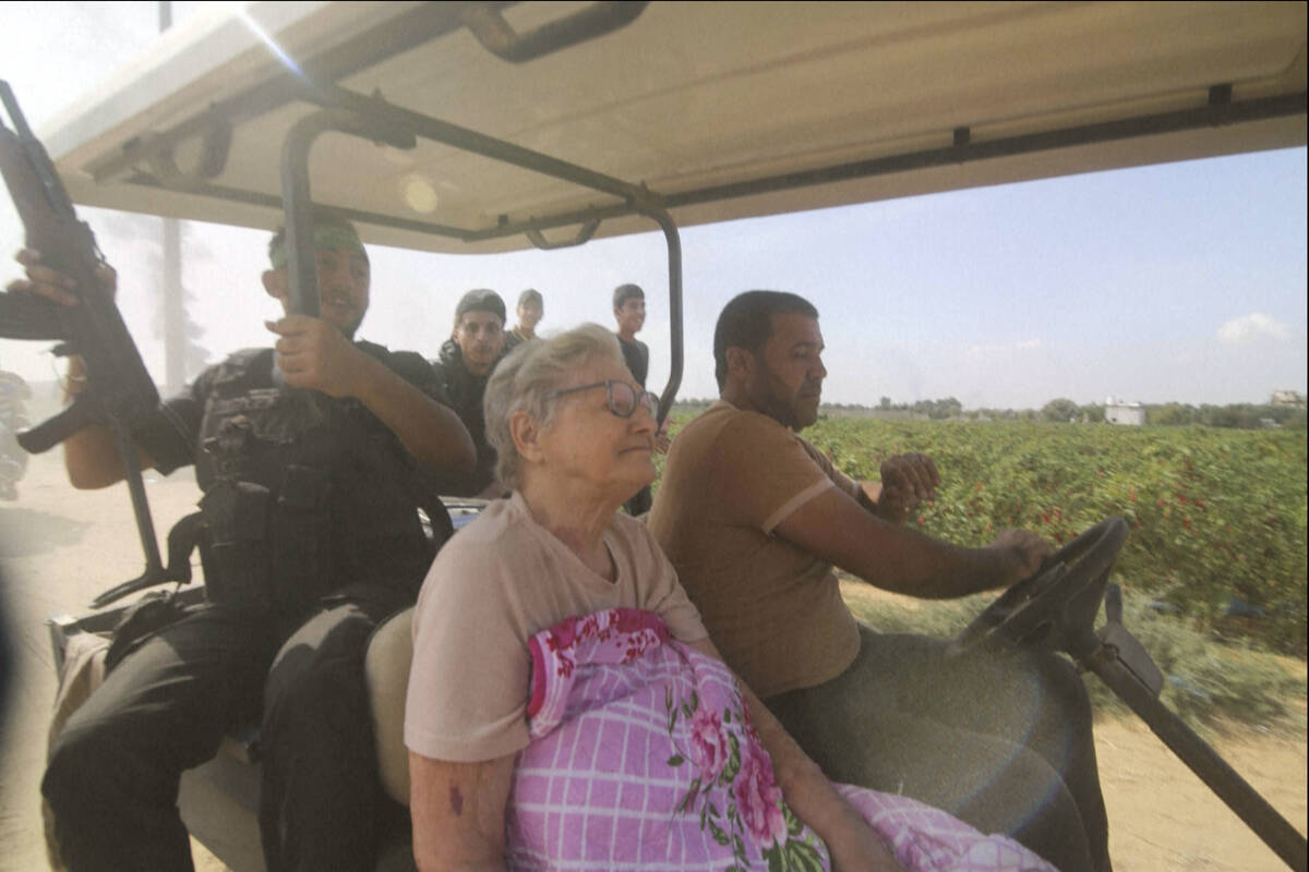 In this still image taken from video, Hamas' militants transport Yaffa Adar, 85, an Israeli civ ...