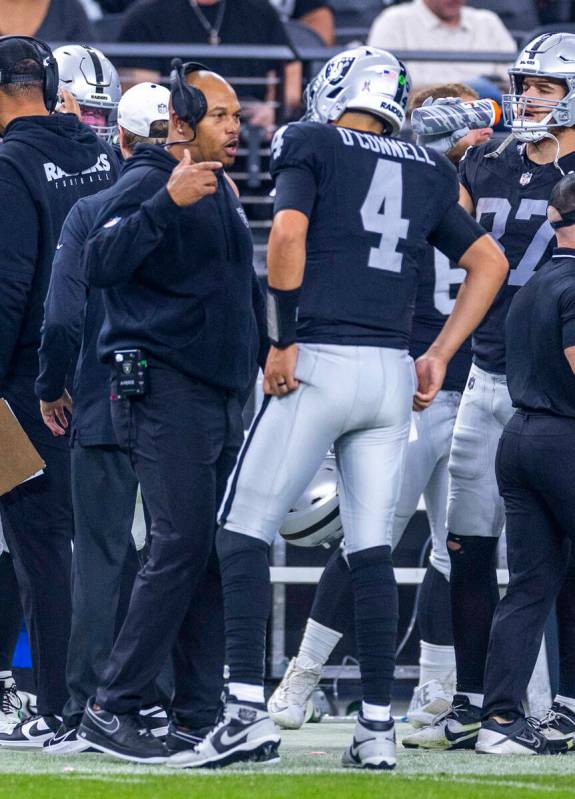 Raiders interim Head Coach Antonio Pierce speaks with quarterback Aidan O'Connell (4) during th ...