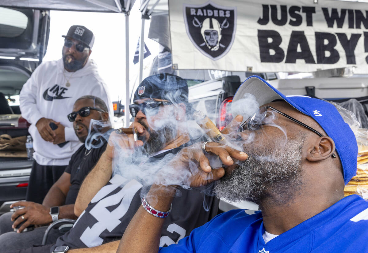 Fans enjoy cigars in the tailgating area before the start of the Raiders against the New York G ...