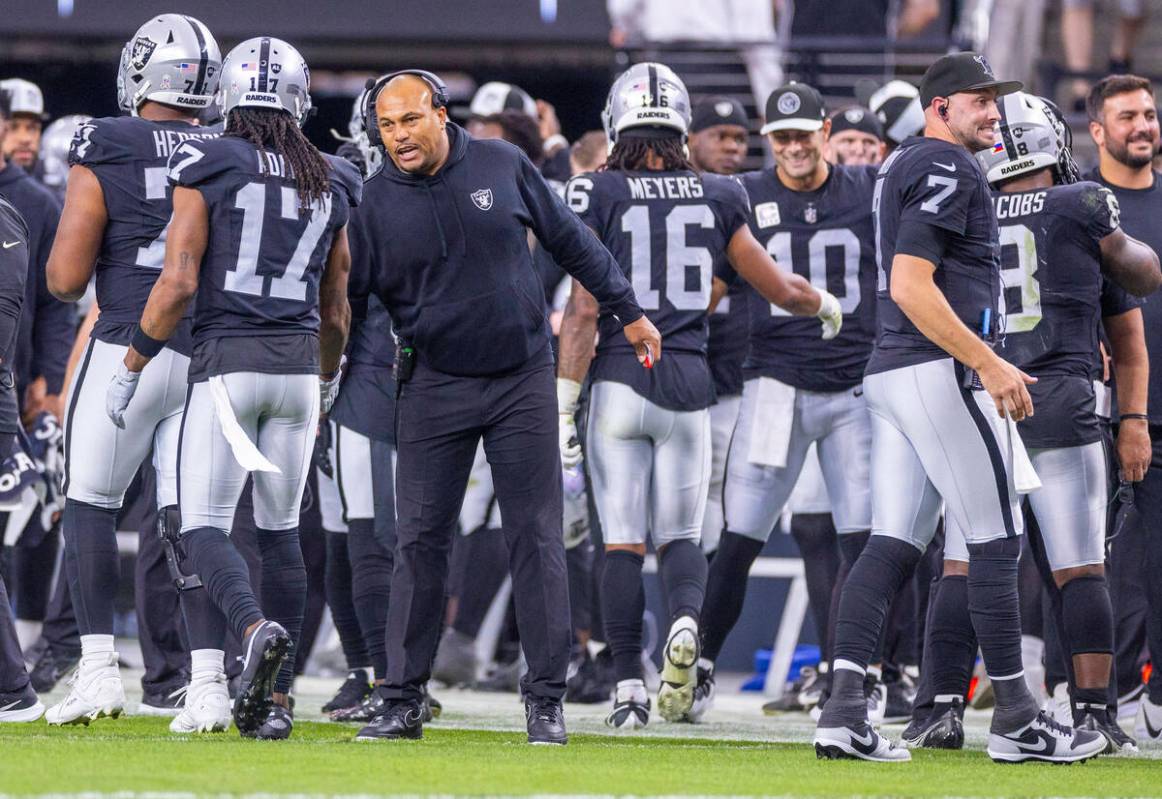 Raiders interim Head Coach Antonio Pierce chats with wide receiver Davante Adams (17) against t ...