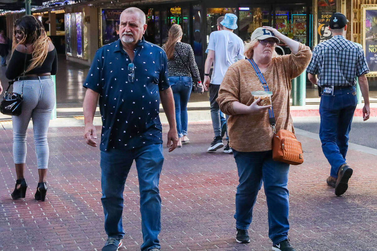 Tourists battle through the wind along Fremont Street on Monday, Nov. 6, 2023 in Las Vegas. (Da ...