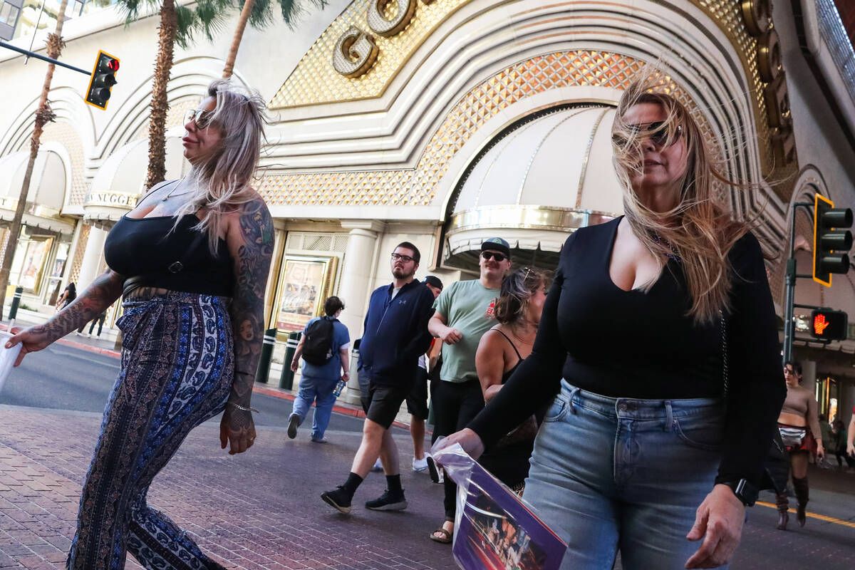 Tourists battle through the wind along Fremont Street on Monday, Nov. 6, 2023 in Las Vegas. (Da ...