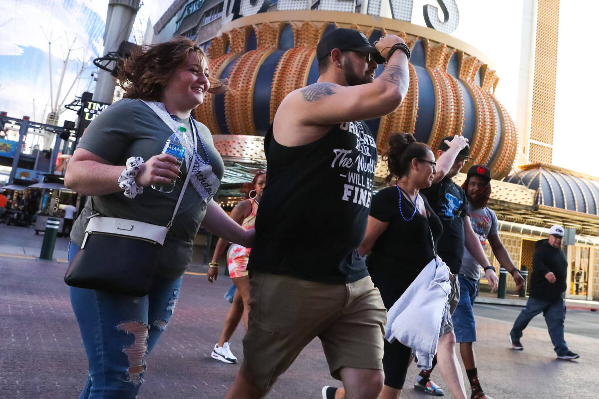 Tourists battle through the wind along Fremont Street on Monday, Nov. 6, 2023 in Las Vegas. (Da ...