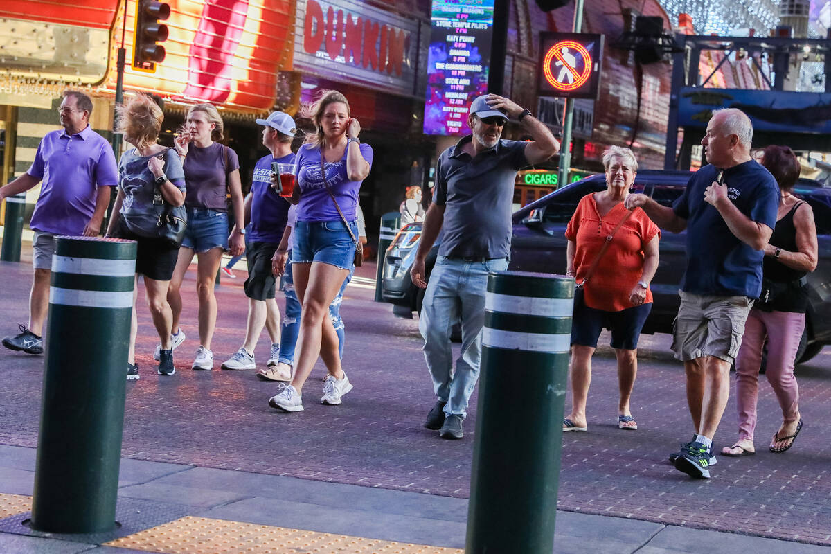 Tourists battle through the wind along Fremont Street on Monday, Nov. 6, 2023 in Las Vegas. (Da ...