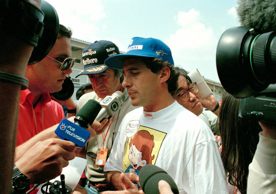 Brazilian driver Ayrton Senna is surrounded by reporters after he withdrew from the Formula One ...