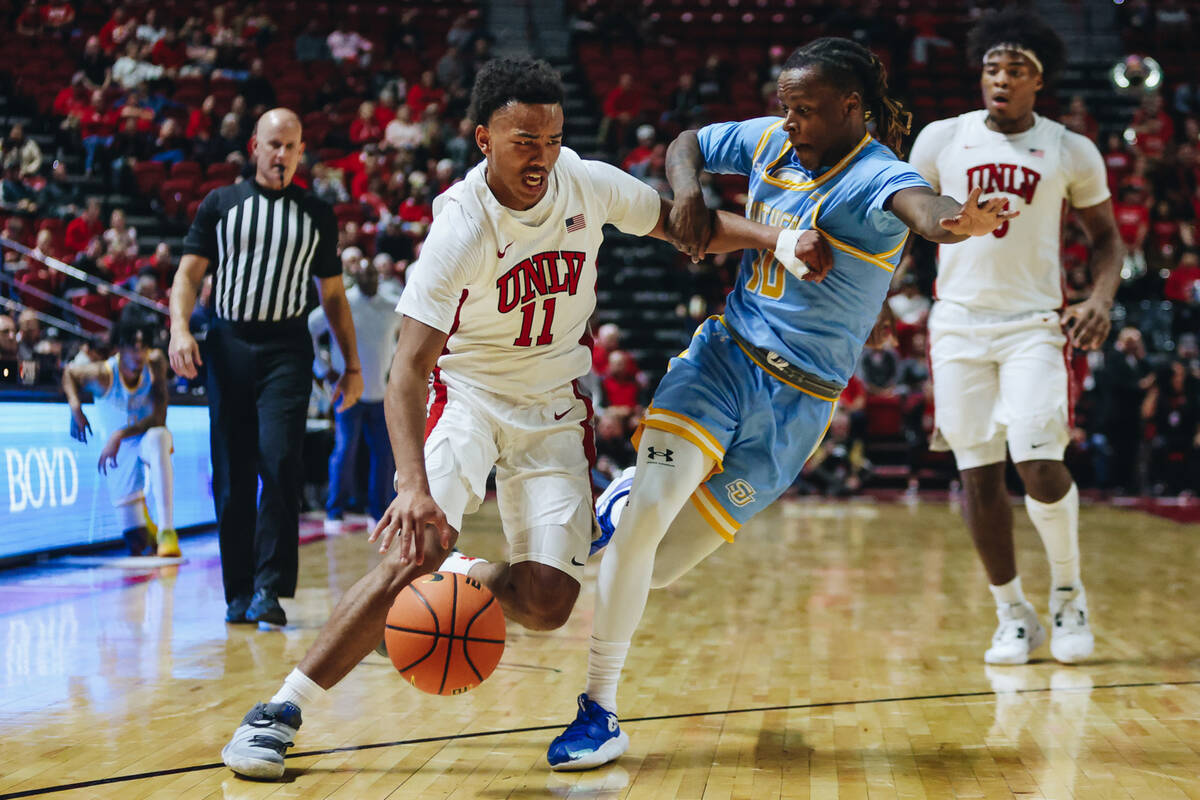 UNLV guard Dedan Thomas Jr. (11) drives the ball as Southern guard Brandon Davis (10) guards hi ...