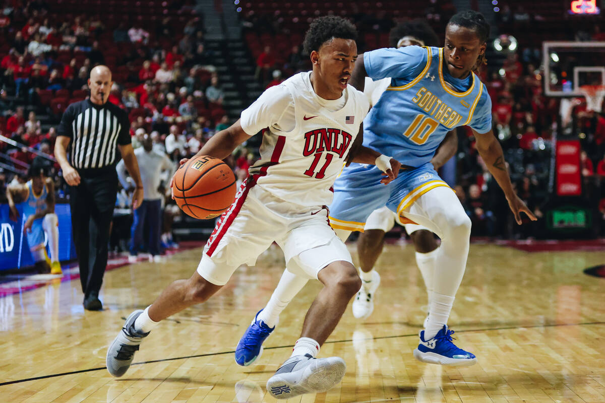 UNLV guard Dedan Thomas Jr. (11) drives the ball as Southern guard Brandon Davis (10) guards hi ...