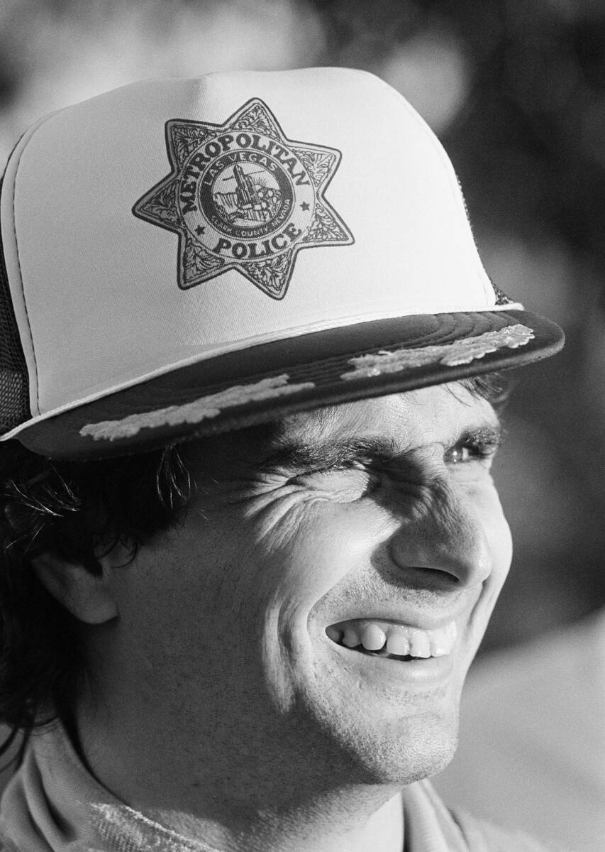 Nelson Piquet of Brazil smiles as he wears a Las Vegas city police cap given to him following h ...