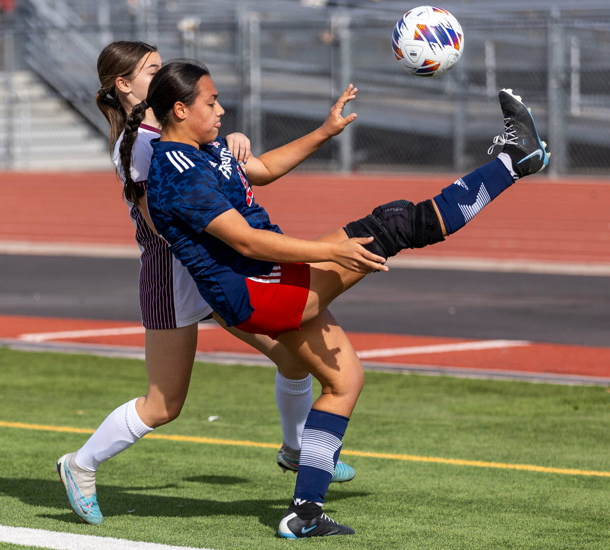 Liberty defender Leilani Harworth (22) kicks the ball backwards with pressure by Faith Lutheran ...