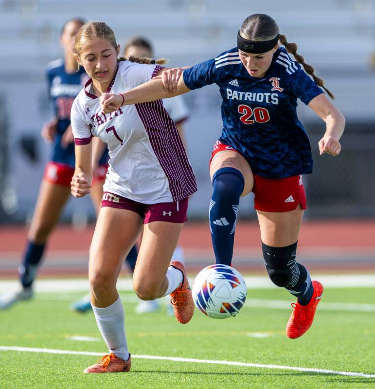 Faith Lutheran midfielder Julia Vancura (7) grabs Liberty midfielder Madisyn Marchesi (20) as s ...