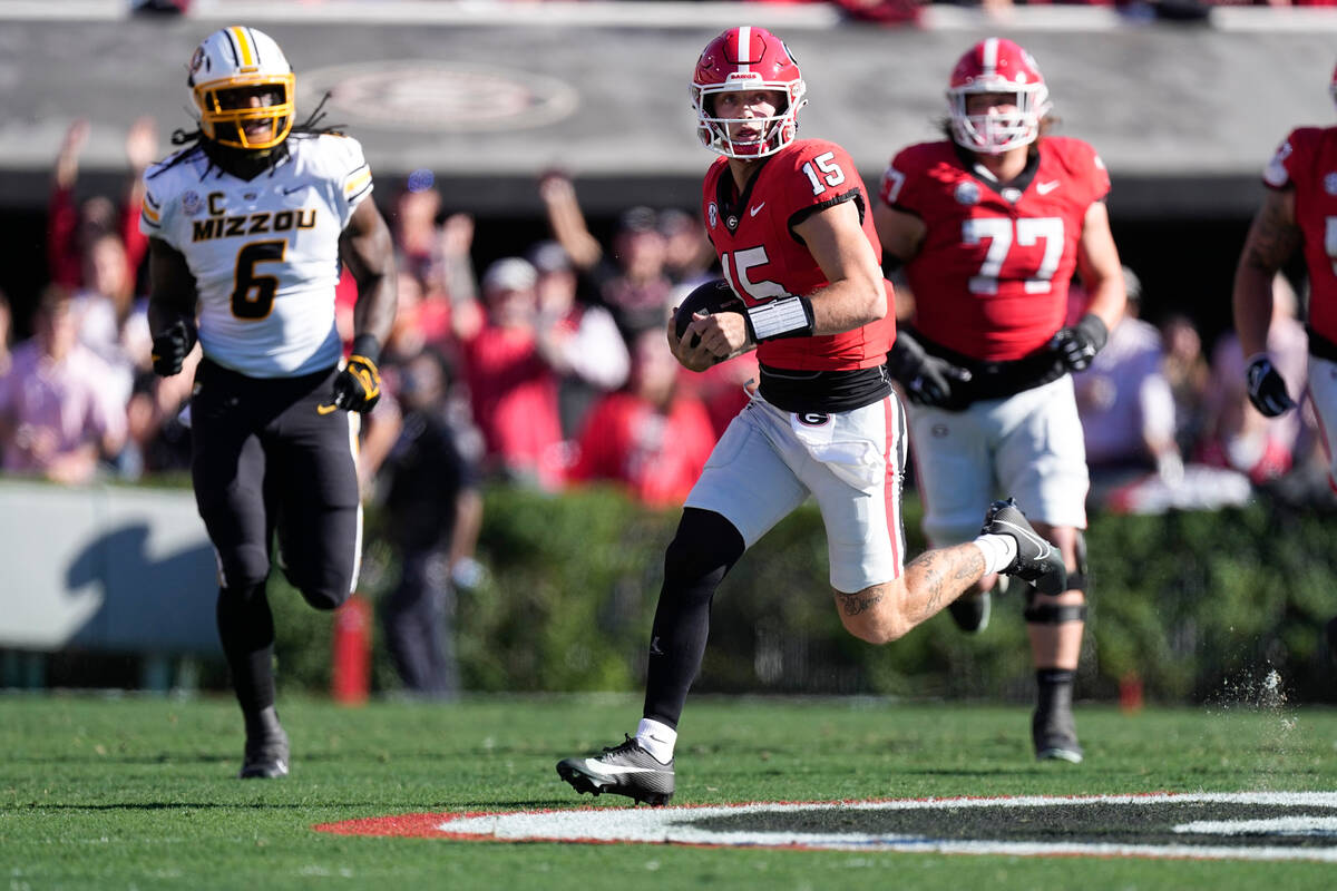 Georgia quarterback Carson Beck (15) scrambles as Missouri defensive lineman Darius Robinson (6 ...