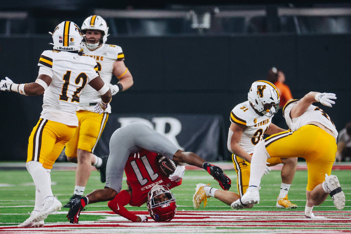 UNLV wide receiver Ricky White (11) lands on his head with the ball during game against Wyoming ...