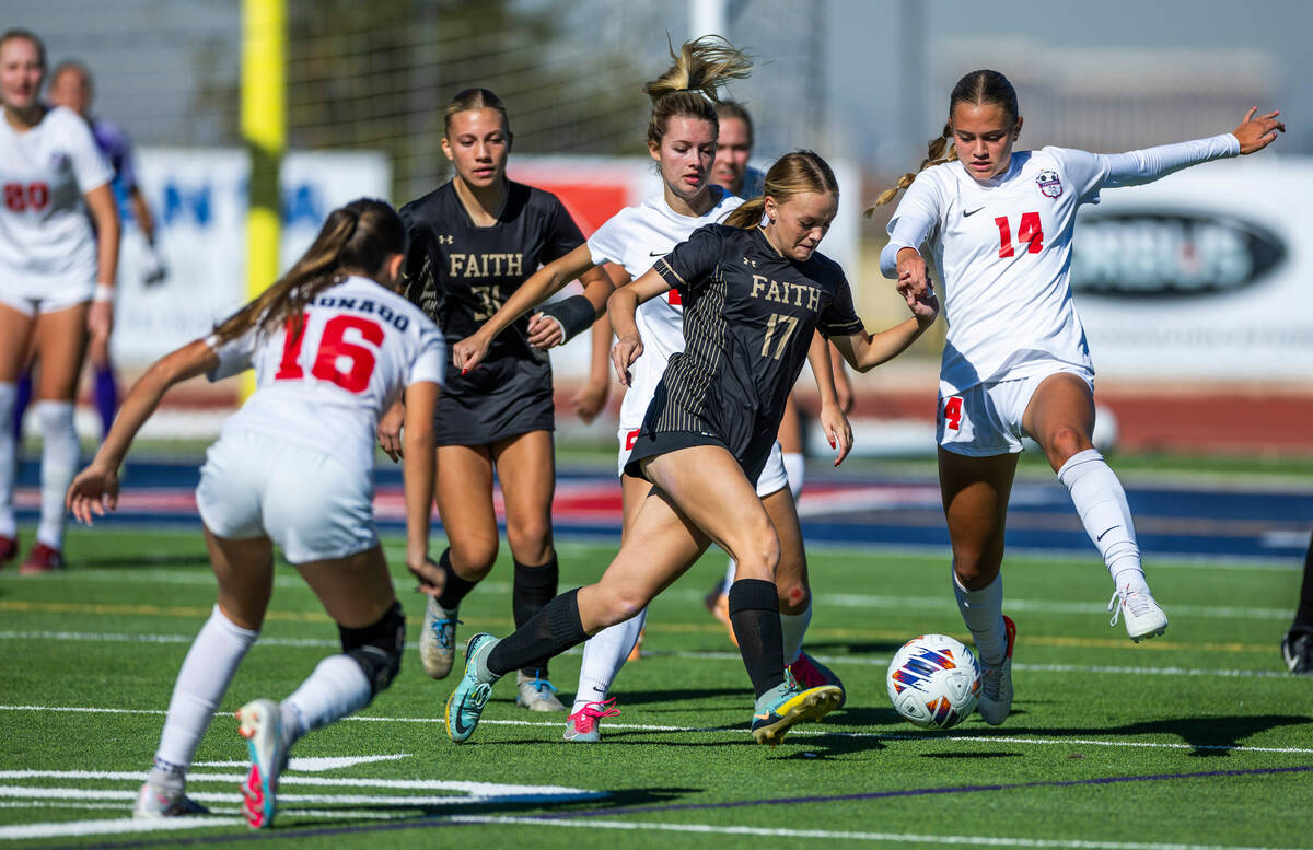 Faith Lutheran forward Julia Anfinson (17) battles for the ball against Coronado defender Allis ...