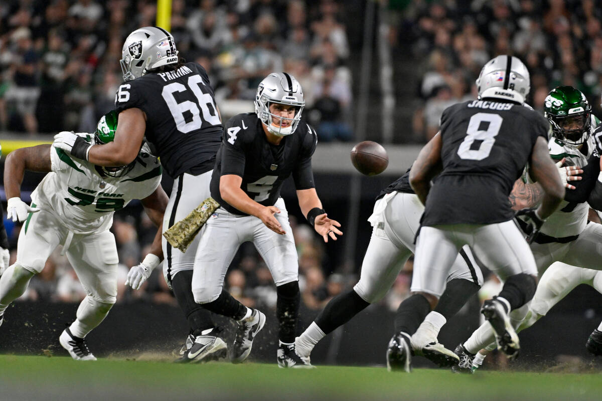 Las Vegas Raiders quarterback Aidan O'Connell (4) tosses to running back Josh Jacobs (8) during ...