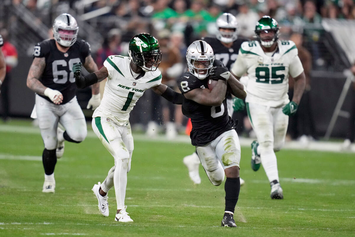 Las Vegas Raiders running back Josh Jacobs (8) runs with the ball as New York Jets cornerback S ...