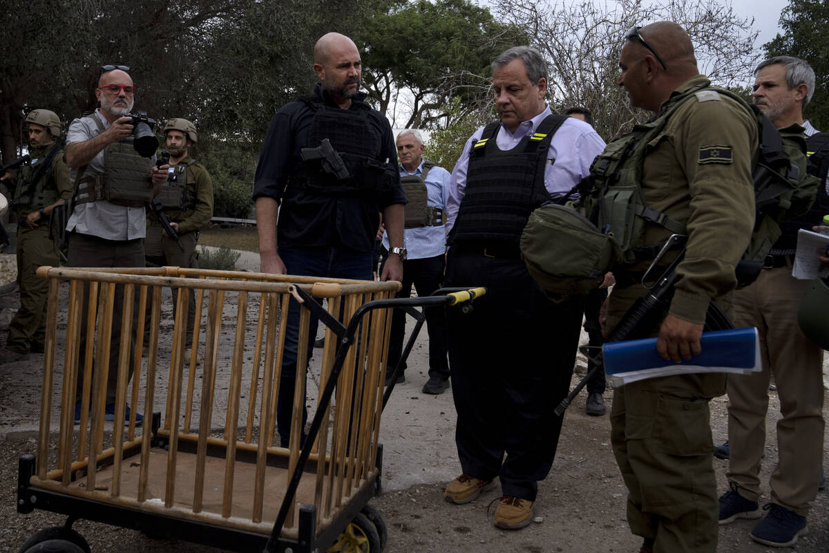 Former New Jersey Governor Chris Christie, center right, looks at a baby carriage as he visits ...