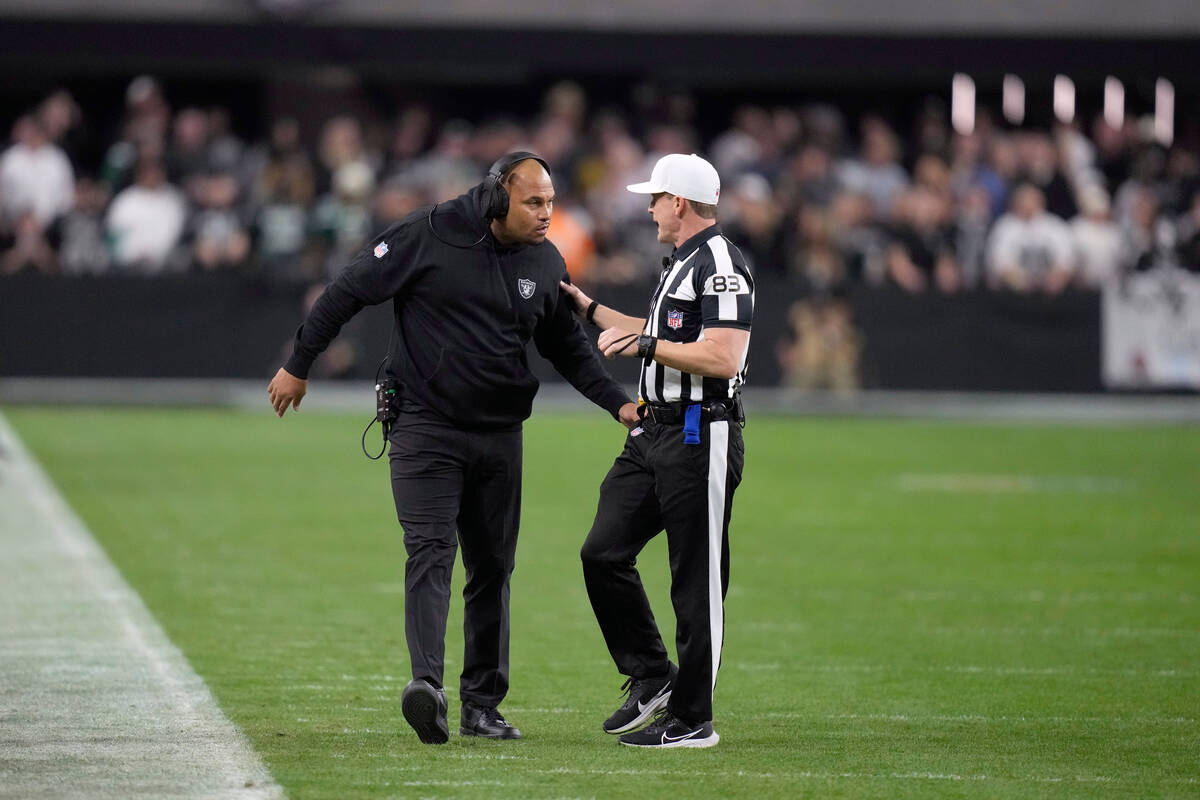 Las Vegas Raiders interim head coach Antonio Pierce talks with referee Shawn Hochuli (83) durin ...