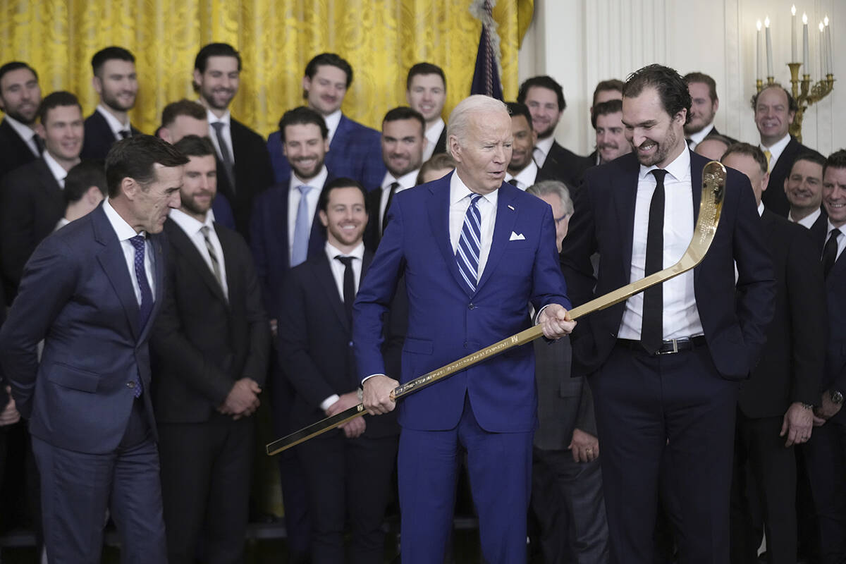 President Joe Biden looks over a hockey stick with team captain Mark Stone, during an event to ...