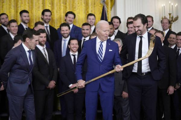 President Joe Biden looks over a hockey stick with team captain Mark Stone, during an event to ...