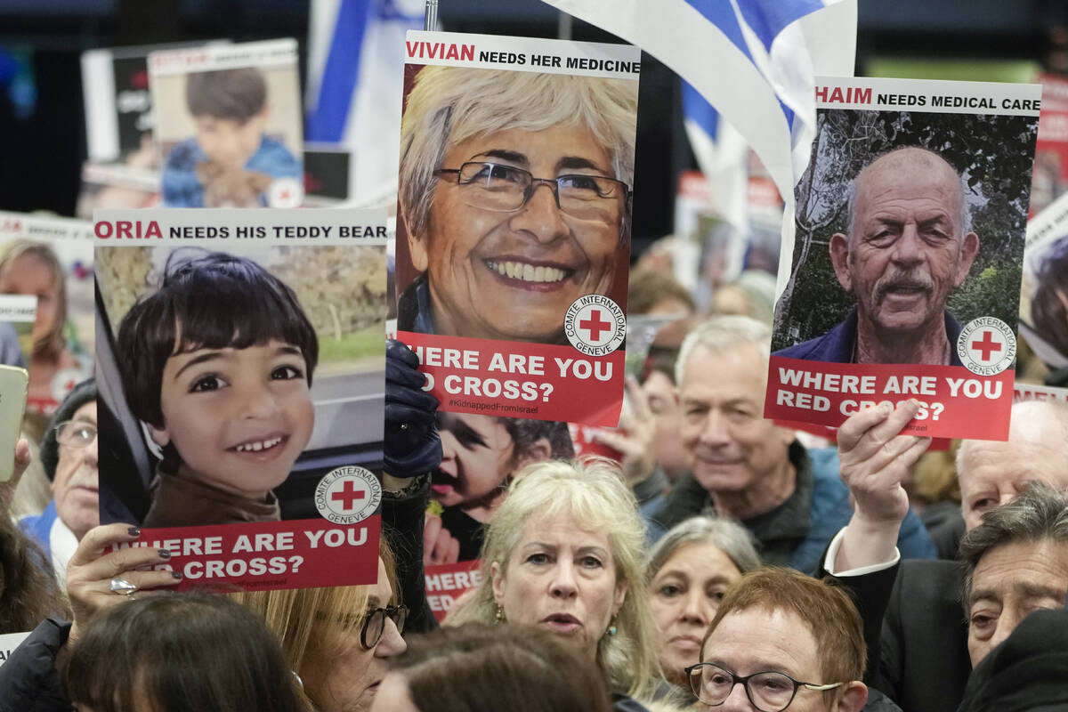 A person holds a poster of Vivian Silver ,top center, as medical staff and health professional ...