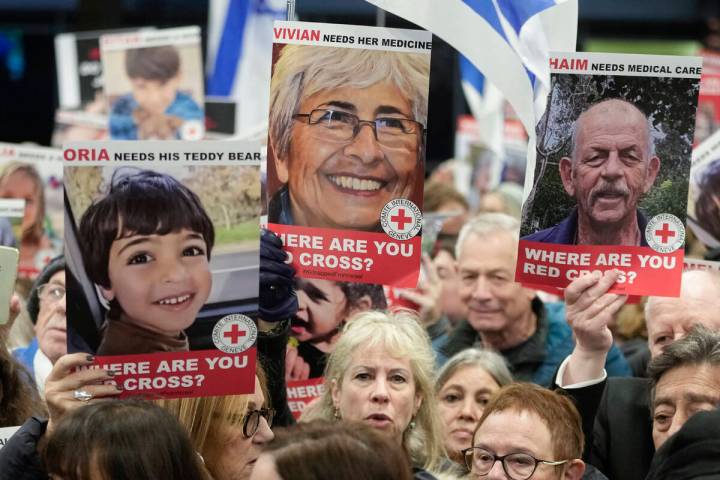 A person holds a poster of Vivian Silver ,top center, as medical staff and health professional ...
